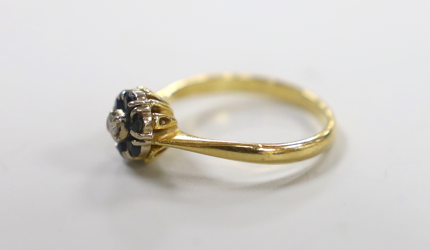 A modern yellow metal, sapphire and diamond cluster set ring, size M, gross weight 2.8 grams.